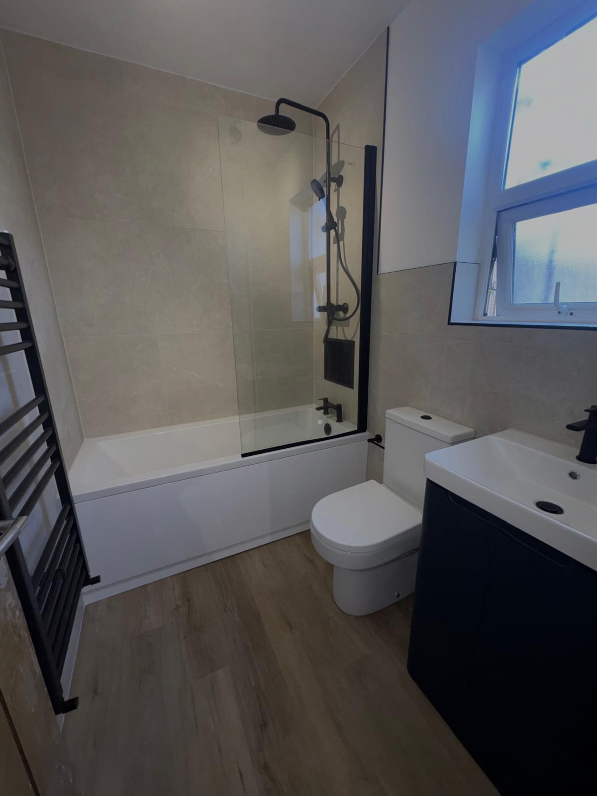 Bathroom with bath, black fittings and navy vanity