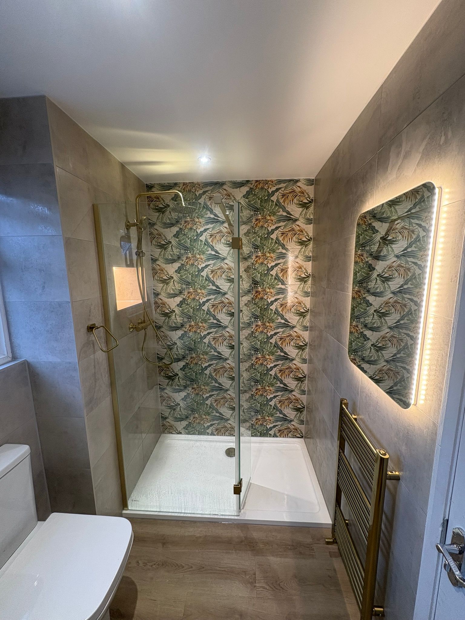 Walk-in shower with botanical feature wall and gold fittings